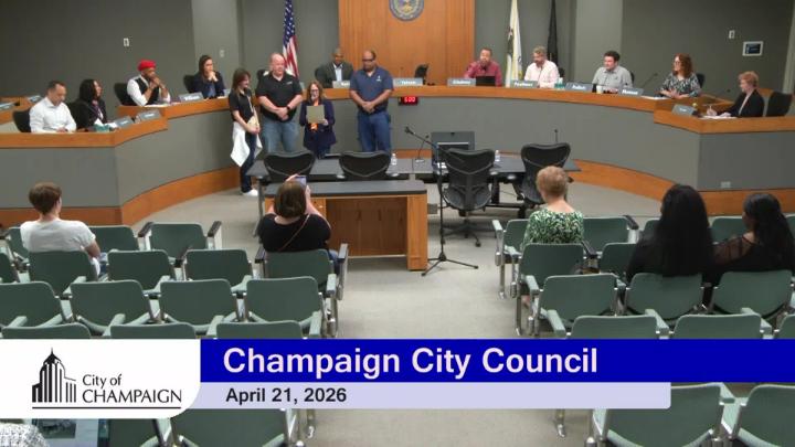 Wide shot of Council Chambers with group standing up front for proclamation. 