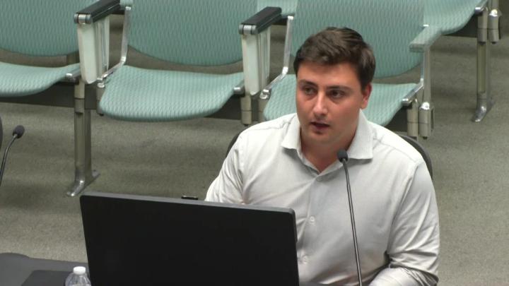 Planner, Dan Saphiere, sitting at presentation table with laptop open. 